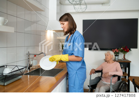 Care assistant cleaning the kitchen after breakfast 127417808