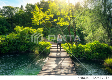 Young woman with backpack on wooden path in Plitvice Lakes Young woman with backpack on wooden path in Plitvice Lakes 127417917