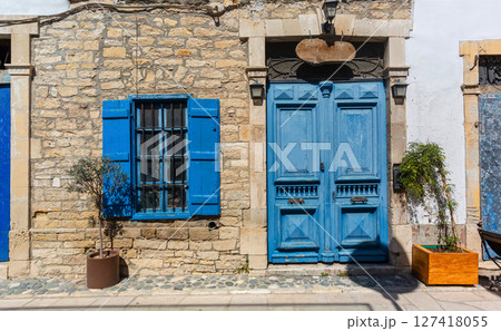 Blue door and window shutters adding charm to traditional stone house 127418055