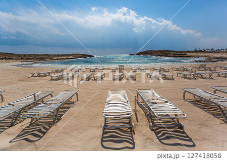 Empty sunbeds inviting tourists on sandy beach in cyprus 127418058