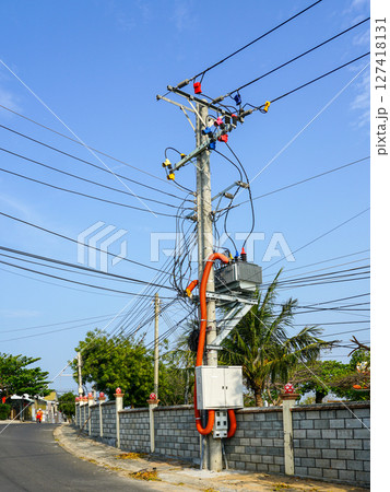Street power pole with complex electric wiring and colorful connectors against a clear blue sky in Vietnam Street power pole with complex electric wiring and colorful connectors against a clear blue sky in Vietnam 127418131