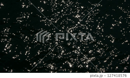 Water surface high contrast top view. Sun glare on water black and white edit. Background abstracted wallpaper texture 127418576