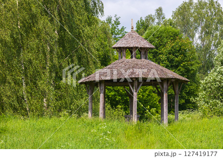 A charming empty wooden gazebo surrounded by vibrant greenery A charming empty wooden gazebo surrounded by vibrant greenery 127419177
