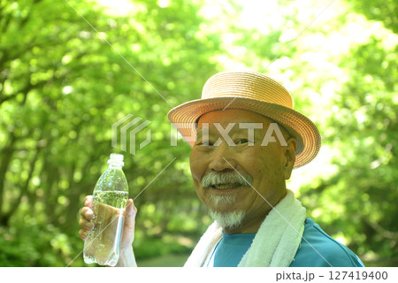 渓流で水分補給をする老人 127419400
