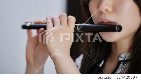 ピッコロを吹く若い女性 127420597