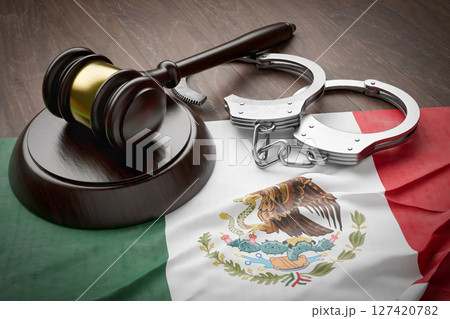 Gavel and Handcuffs Resting on a Tattered and Dirty Mexican Flag. Gavel and Handcuffs Resting on a Tattered and Dirty Mexican Flag. 127420782