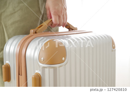 旅行バッグを持つシニア女性の手元 127420810