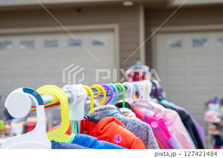 Clothes rack with hangers and assorted items at a garage sale 127421484