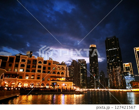 Beautiful evening view of downtown Dubai, showcasing the glowing skyscrapers and modern architecture illuminated against the twilight sky. The cityscape captures the vibrant atmosphere of Dubai. 127421567