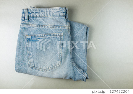 Casual blue denim jeans folded neatly on a flat surface 127422204