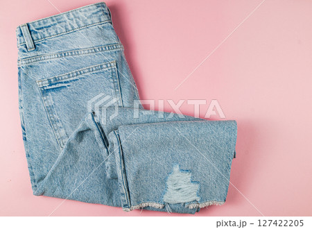 Stylish ripped denim jeans on pink background Stylish ripped denim jeans on pink background 127422205