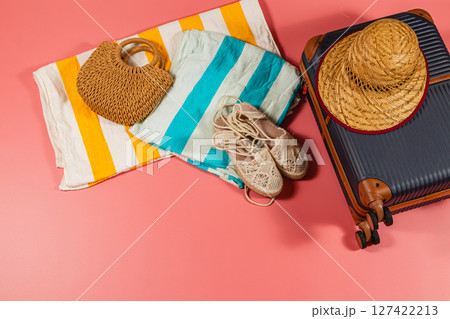 Packing for a beach vacation with essentials on colorful backdrop Packing for a beach vacation with essentials on colorful backdrop 127422213