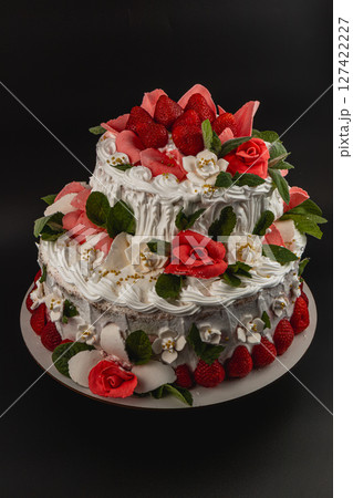 Beautiful two-tiered cake decorated with strawberries and flowers 127422227