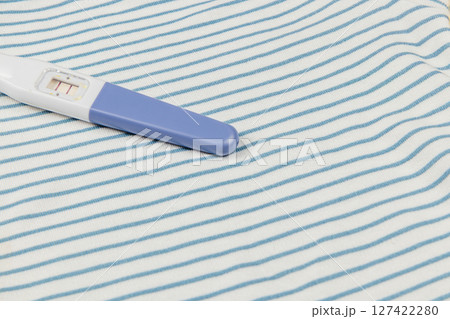 Pregnancy test on a striped fabric background Pregnancy test on a striped fabric background 127422280