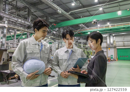 工場を視察する女性ビジネスパーソンと男性作業員 127422559