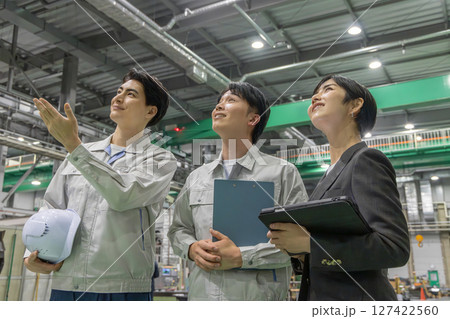 工場を視察する女性ビジネスパーソンと男性作業員 127422560