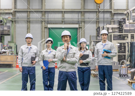 工場の中で考える作業員のグループ 127422589