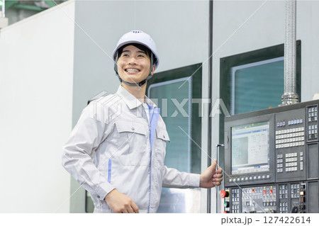 工場の操作盤の前で働く男性作業員 工場の操作盤の前で働く男性作業員 127422614