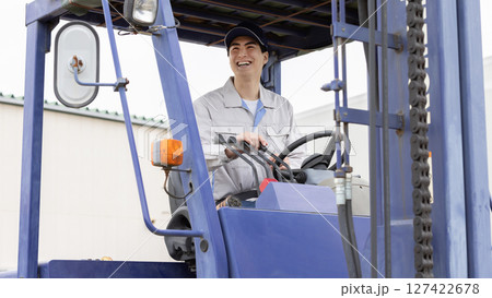 フォークリフトを操作する男性作業員 フォークリフトを操作する男性作業員 127422678