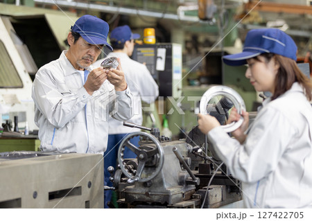 工場で製品を検品する作業員グループ 工場で製品を検品する作業員グループ 127422705