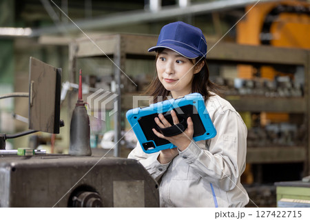 タブレットPCを持って機械を点検する作業員 タブレットPCを持って機械を点検する作業員 127422715