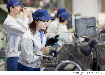 タブレットPCを持って機械を点検する作業員 127422717