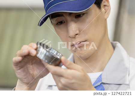 工場で旋盤加工品・フライス加工品を確認する男性作業員 127422721