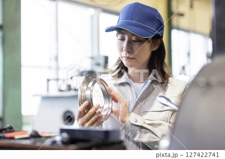 工場で旋盤加工品・フライス加工品を確認する作業員 工場で旋盤加工品・フライス加工品を確認する作業員 127422741