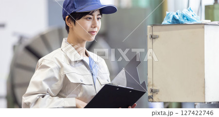 操作盤で工場機械を操作する女性作業員 操作盤で工場機械を操作する女性作業員 127422746