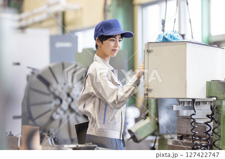 操作盤で工場機械を操作する女性作業員 操作盤で工場機械を操作する女性作業員 127422747