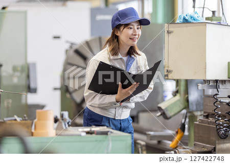 操作盤で工場機械を操作する女性作業員 127422748