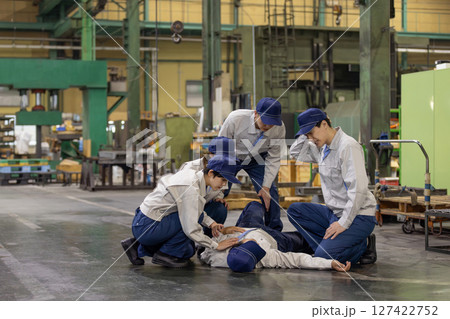 工場で倒れた作業員を救護するグループ 工場で倒れた作業員を救護するグループ 127422752