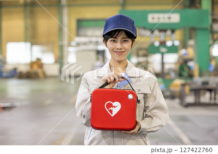 工場でAEDを持つ女性作業員 127422760