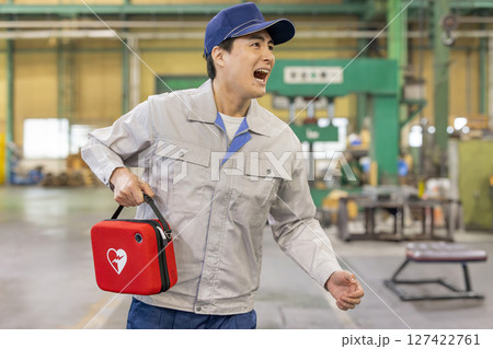 工場でAEDを持って駆けつける男性作業員 127422761