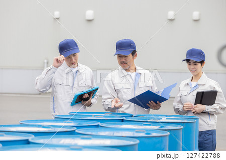 ドラム缶の在庫管理する作業員グループ 127422788