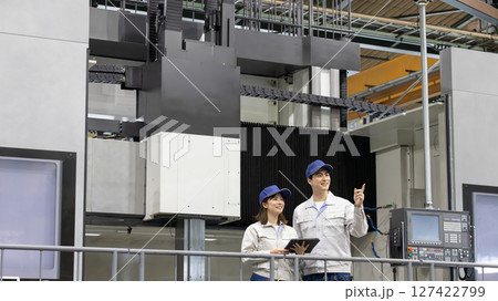 日本最大級の旋盤加工機の前で働く男女作業員 日本最大級の旋盤加工機の前で働く男女作業員 127422799
