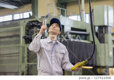 天井クレーン・玉掛けのコントローラを操作する作業員 127422806