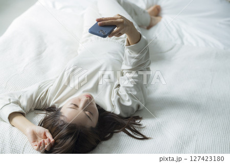 ベッドでスマホを見る女性 127423180