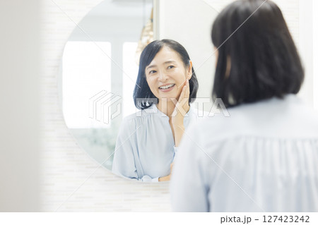 鏡を見るシニア女性 鏡を見るシニア女性 127423242