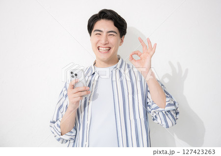 シャツを着た男性 カメラ目線スマホで笑顔のokやgoodのポーズ シャツを着た男性 カメラ目線スマホで笑顔のokやgoodのポーズ 127423263