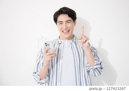 シャツを着た男性 カメラ目線スマホで指差しとポイント シャツを着た男性 カメラ目線スマホで指差しとポイント 127423267