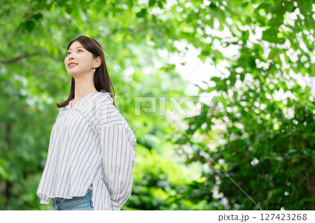 新緑の中に立つ笑顔の女性 127423268