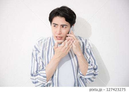 シャツを着た男性 スマホで内緒で話す シャツを着た男性 スマホで内緒で話す 127423275