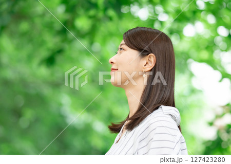 新緑の中に立つ笑顔の女性 新緑の中に立つ笑顔の女性 127423280