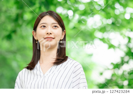 新緑の中に立つ笑顔の女性 新緑の中に立つ笑顔の女性 127423284
