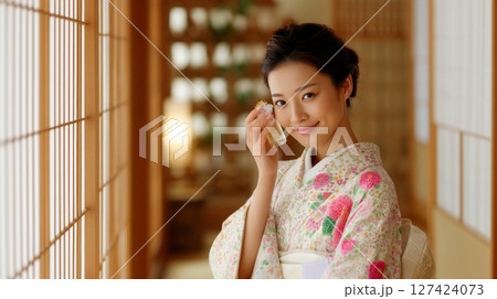 Asian young woman in floral kimono enjoying perfume in traditional setting. 127424073