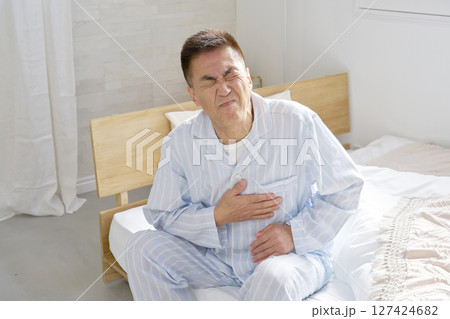 胸が痛いパジャマを着た中年の男性 胸が痛いパジャマを着た中年の男性 127424682