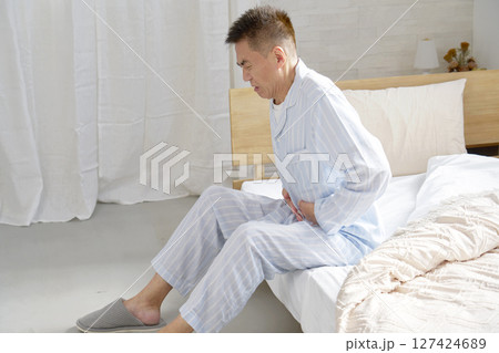 腹痛のパジャマを着た中年の男性 127424689