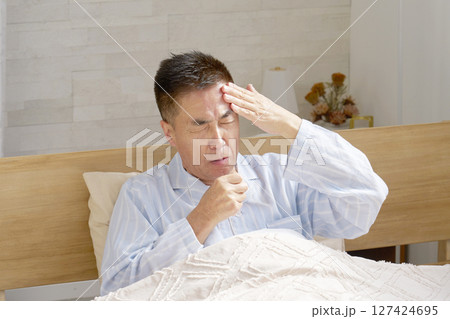 咳をするパジャマを着た中年の男性 127424695