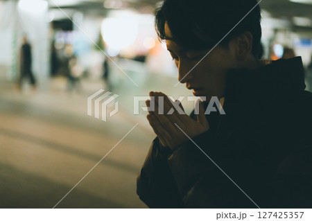 寒さで手に息を吹きかける20代男性 127425357